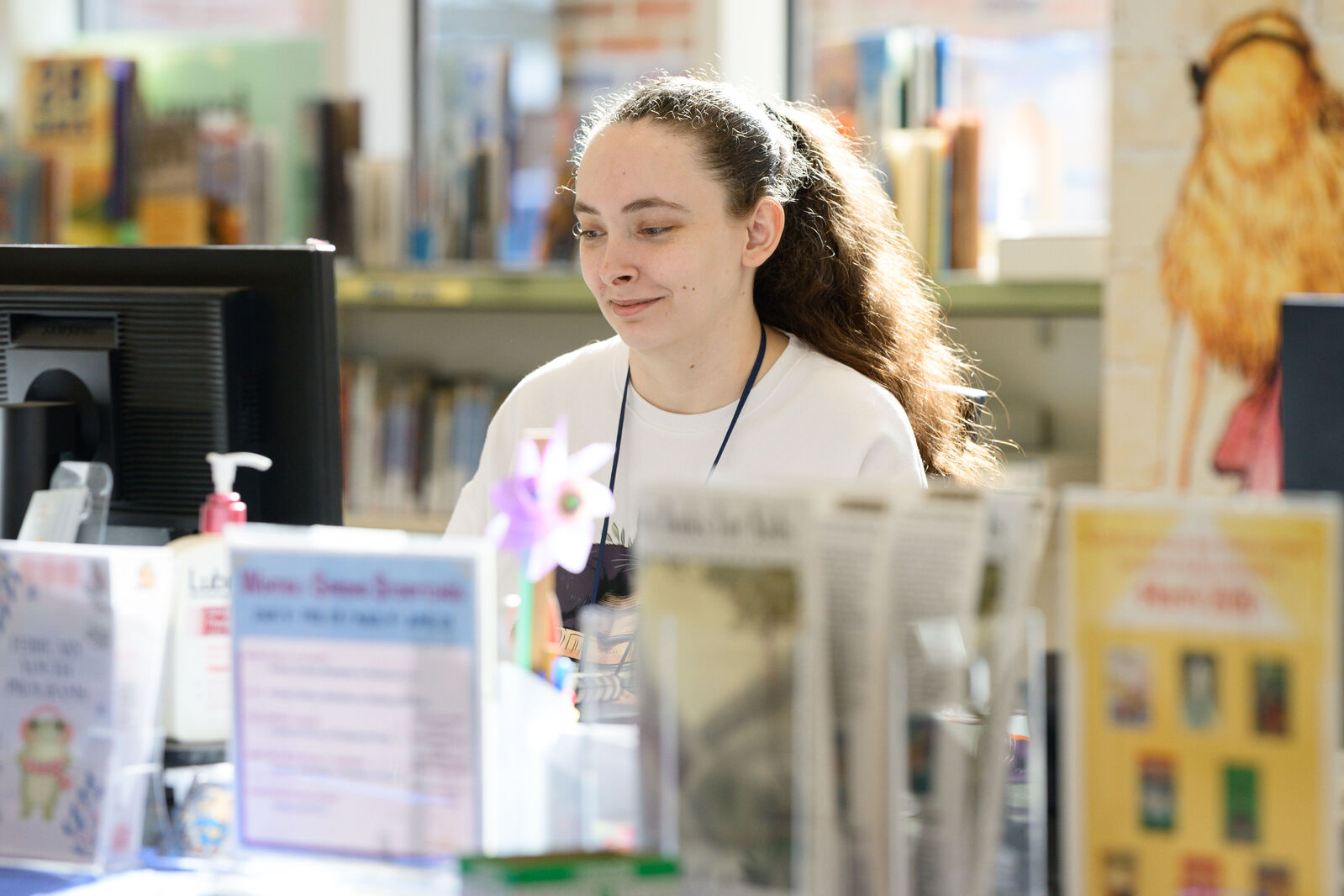 librarian seated at children's desk looking at computer