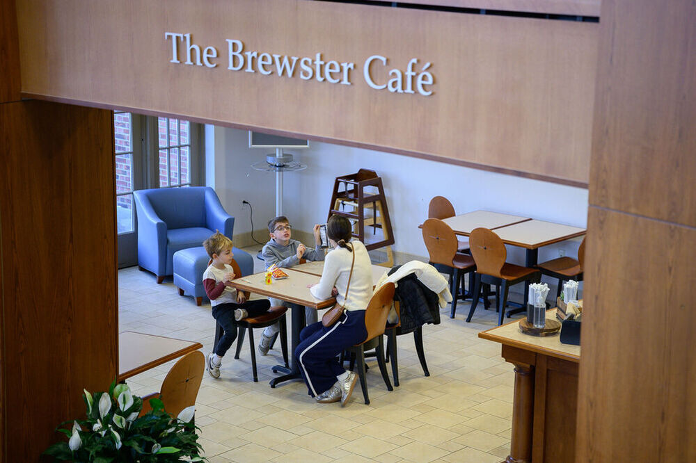 Family seated in cafe, sign overhead reads 